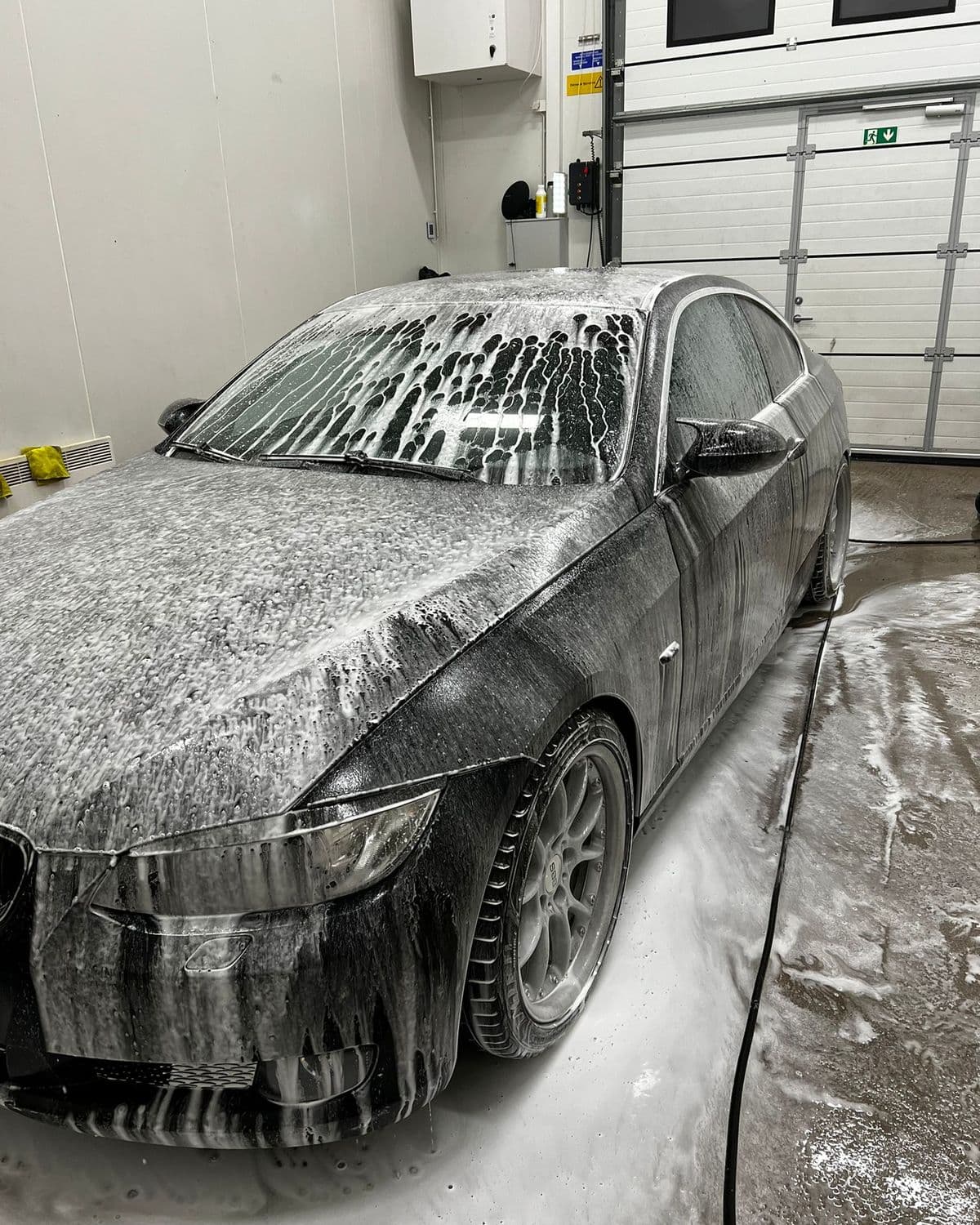 BMW täckt av rinnande skum i tvätthallen hos KOM-fort Bilvård i Örebro