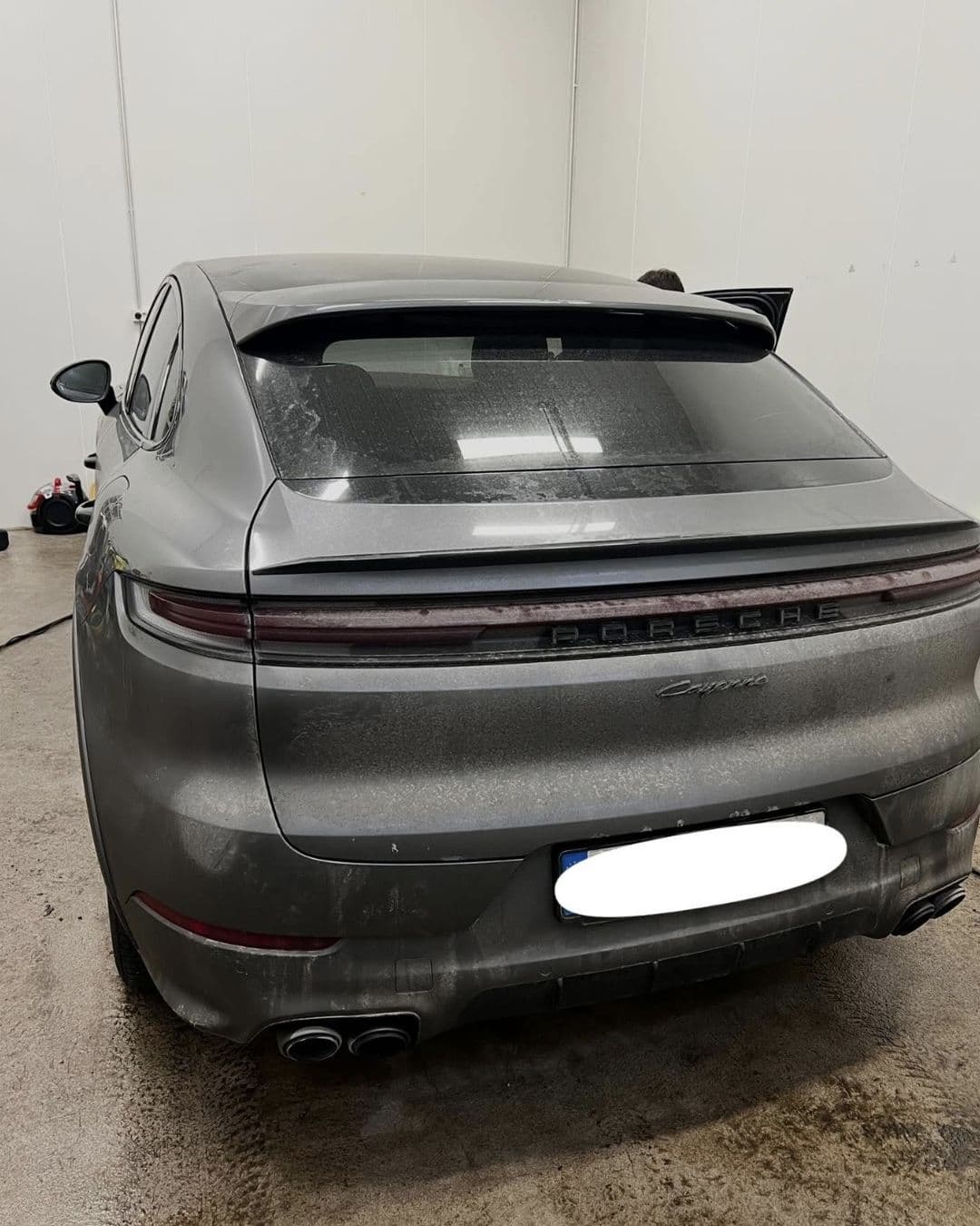 Bakpartiet på en grå Porsche Cayenne täckt av vägsmuts före tvätten hos KOM-fort Bilvård i Örebro