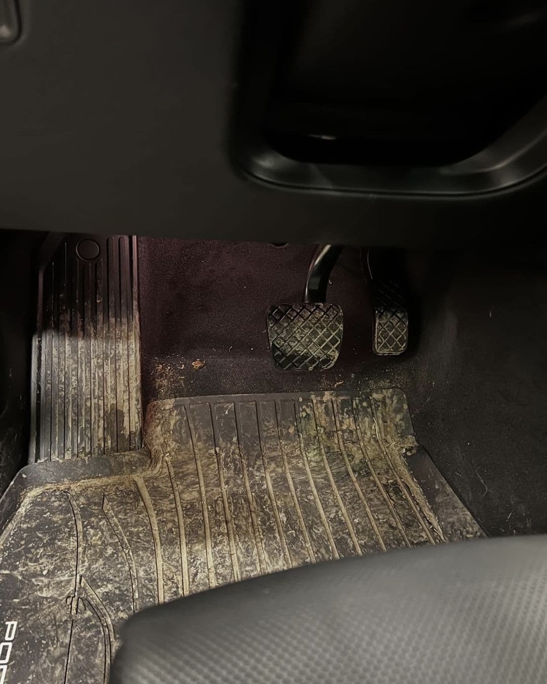 Golvmatta med grus och intorkad smuts i en Porsche Cayenne före rengöringen hos KOM-fort Bilvård i Örebro