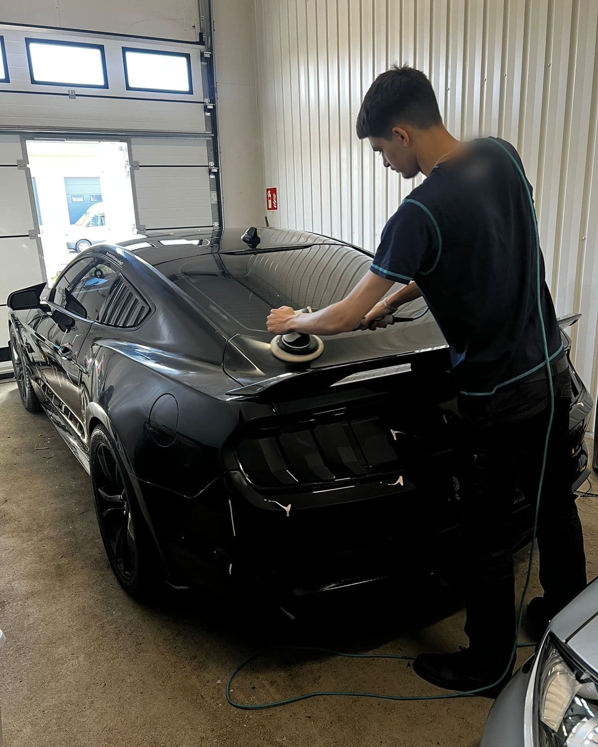 Maskinpolering av bagageluckan på en svart Ford Mustang hos KOM-fort Bilvård i Örebro